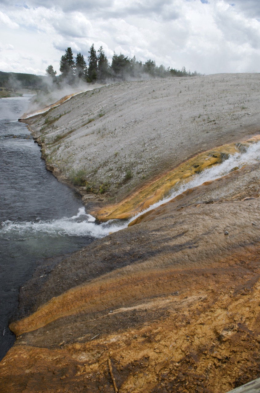 Hot spring water spills into the river and Black Sand Basin.